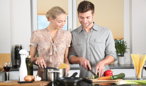 Kvinna och man lagar mat tillsammans.