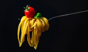 Spaghetti och tomat på en gaffel.