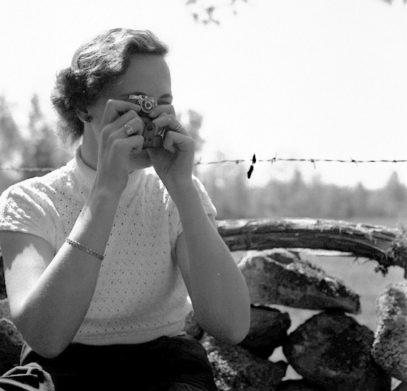 En kvinna fotograferar med en liten kompaktkamera