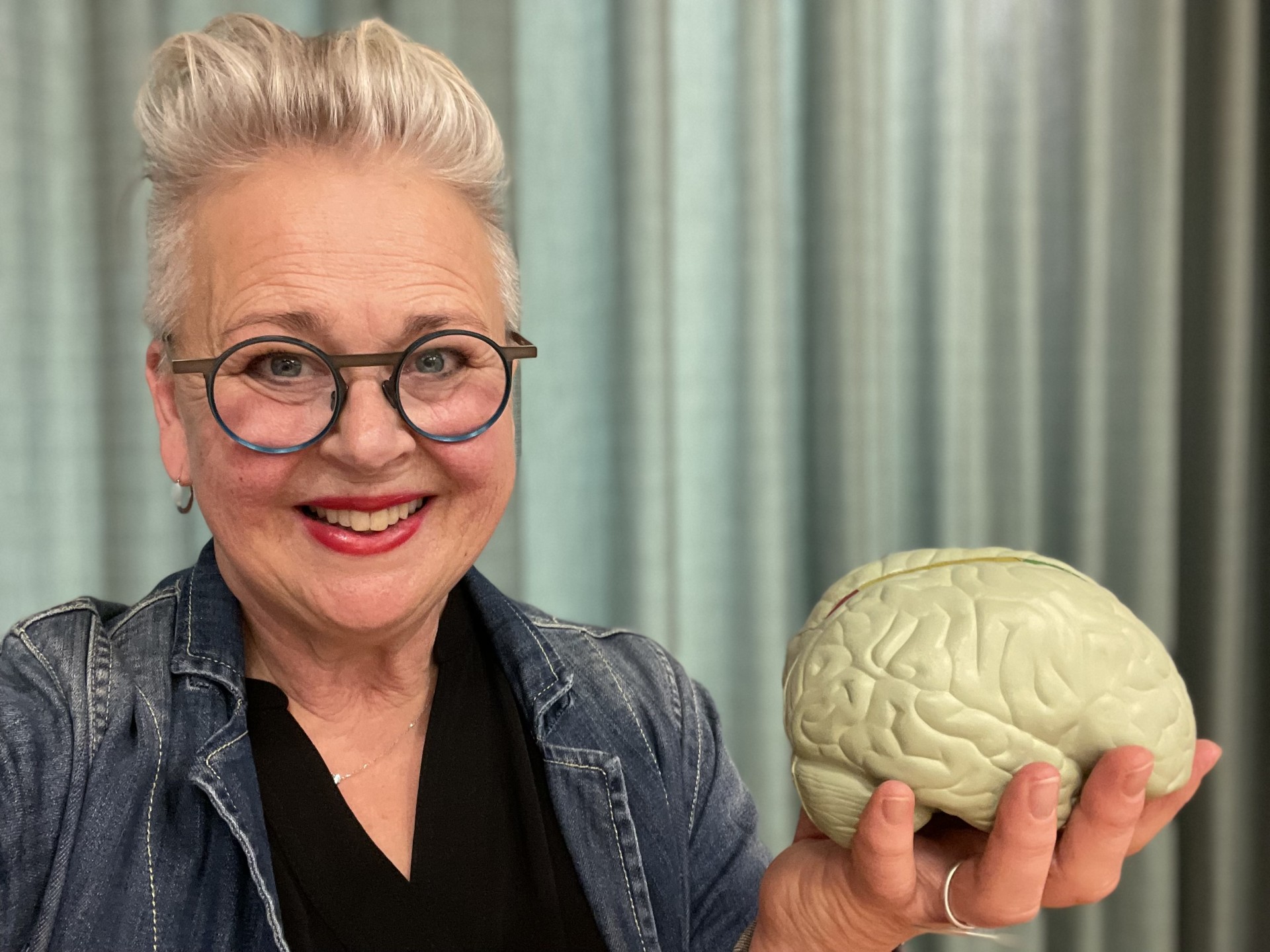 Kvinna håller i modell av en hjärna