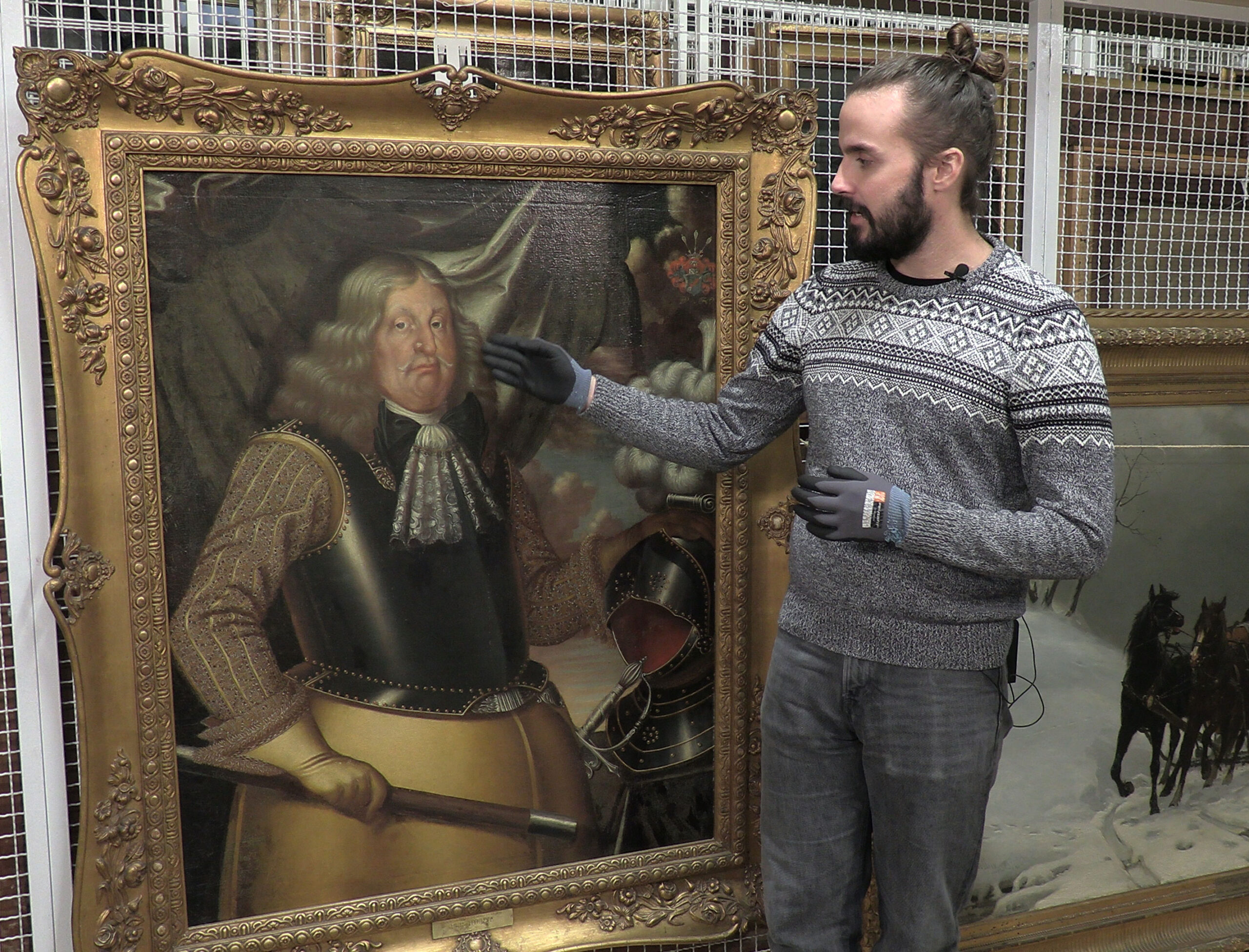 En man bredvid ett porträtt av en 1600-talsman