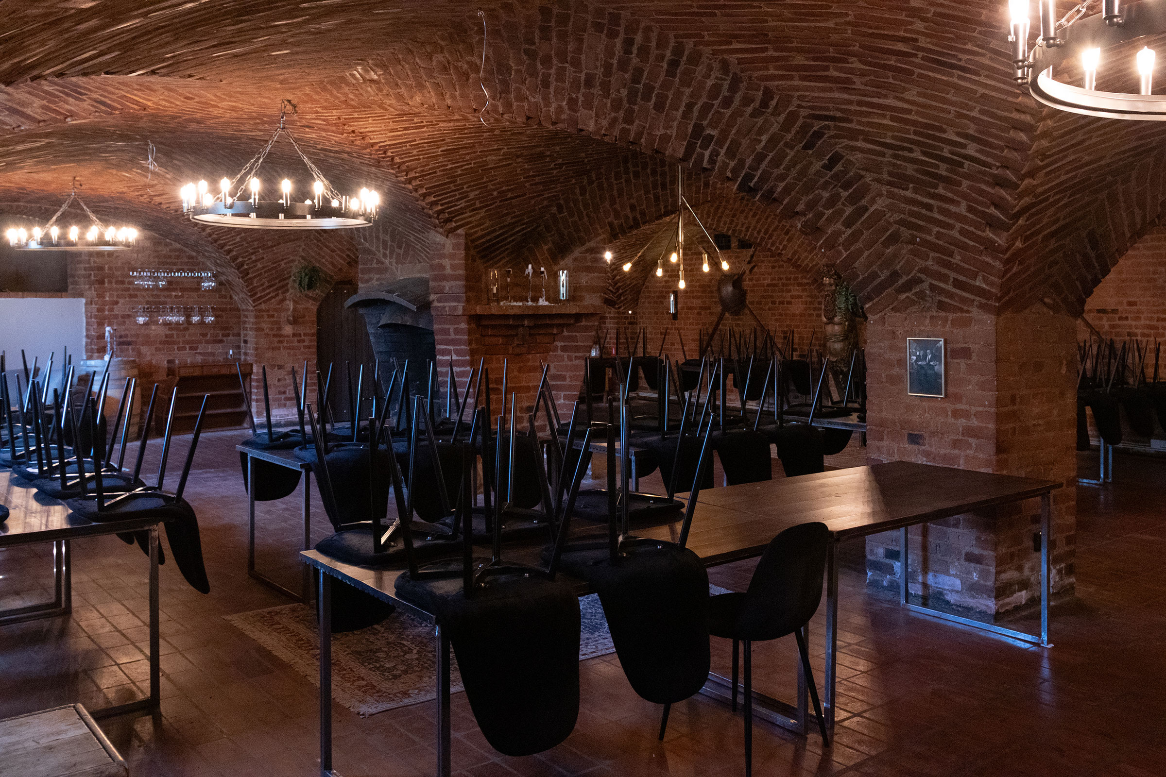 Restaurangmöblering med stolar uppe på borden i en källarlokal med tegelvalv